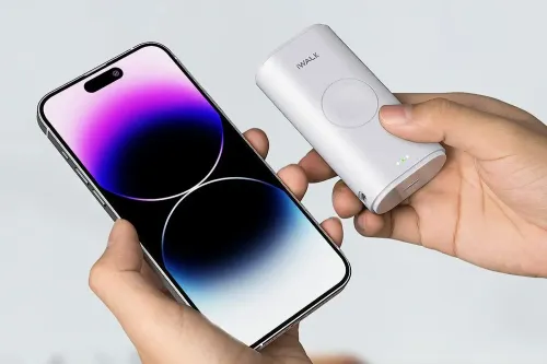 Close up of person holding Portable Apple Watch Charger / Power Bank and smartphone